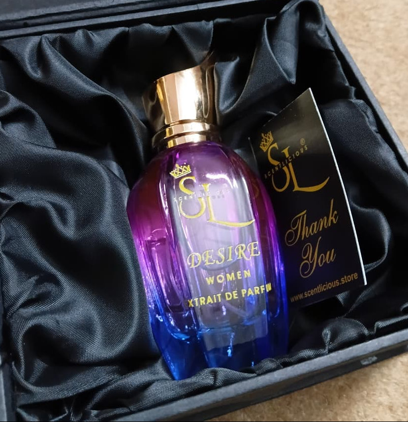 Purple and blue perfume bottle with gold cap in a black box on a beige surface