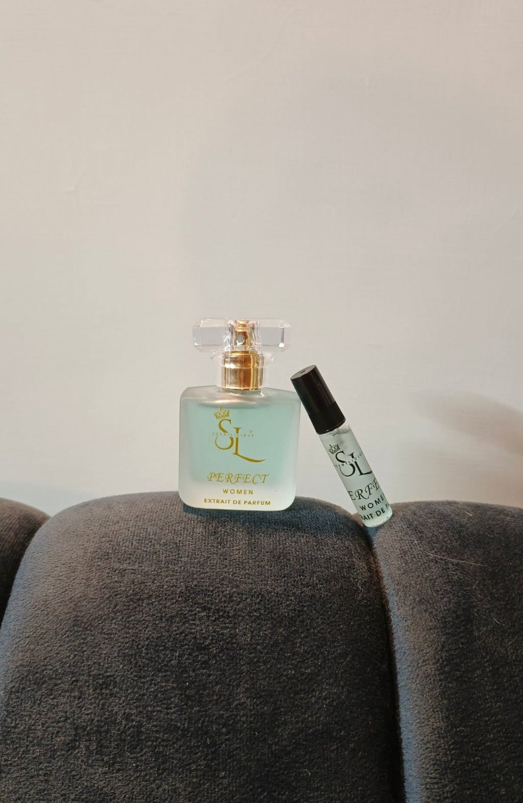 Two perfume bottles on a gray surface with a neutral background