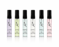 Set of six perfume bottles with black caps on a white background